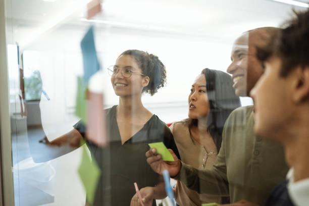 istock Group of young researchers working on new project at university classroom or lecture hall. Students developing new start-up and using sticky notes 1724263437