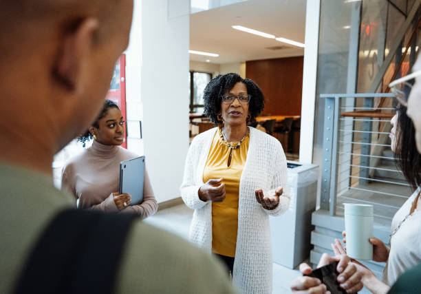 istock University students in campus lobby. Students talking to female African professor during or after the lectures 1724264006
