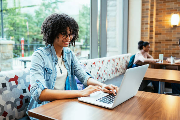 istock Curly multiracial student using laptop in the lobby 1724265677