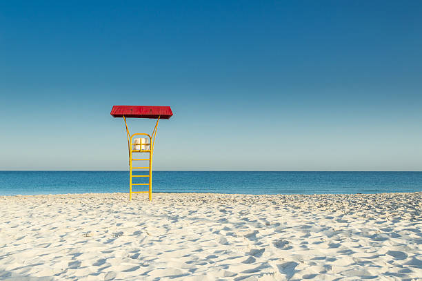 Seascape of Beautiful Pacific Ocean with a Blue Lifeguard Tower on sandy beach over Blue Cloudy Sky on Pacific Coast Road