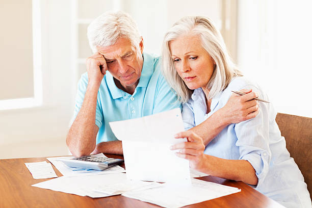 istock Concerned senior couple calculating home finances at a table 172427755