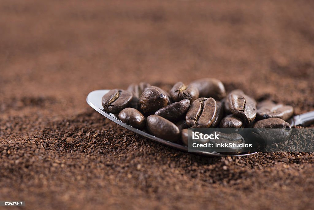 Coffee Beans Coffee beans on a spoon sitting on coffee grounds Brown Stock Photo