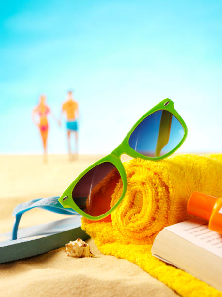istock Sunglasses on a Beach Towel with Background People 172427933