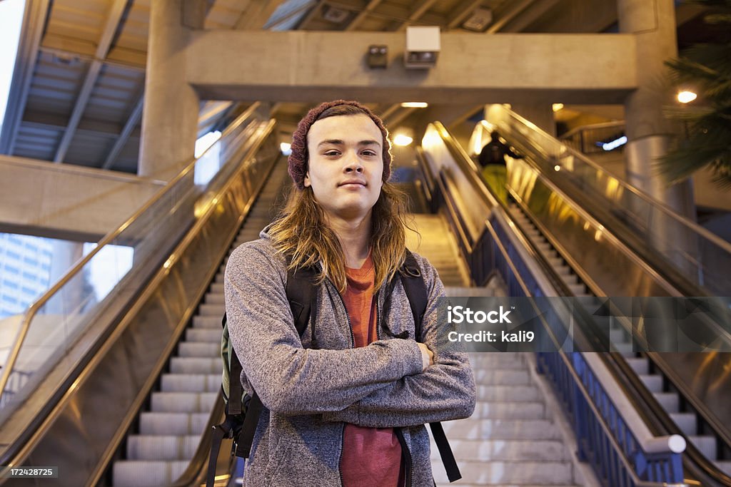 Young man at train station Teenage boy (18 years) in city at bottom of escalator (exiting train station). 18-19 Years Stock Photo