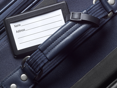 Close up of a blank luggage tag and luggage.