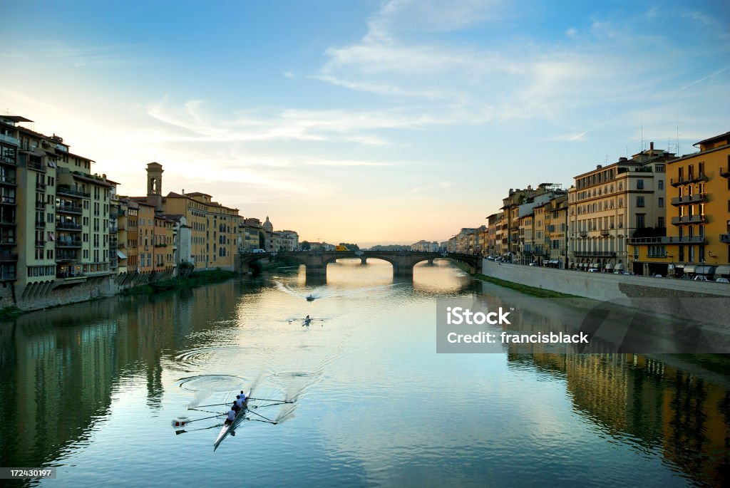 Arno River Florence Italy View of rowers on the Arno River at dusk in Florence Italy Aquatic Sport Stock Photo