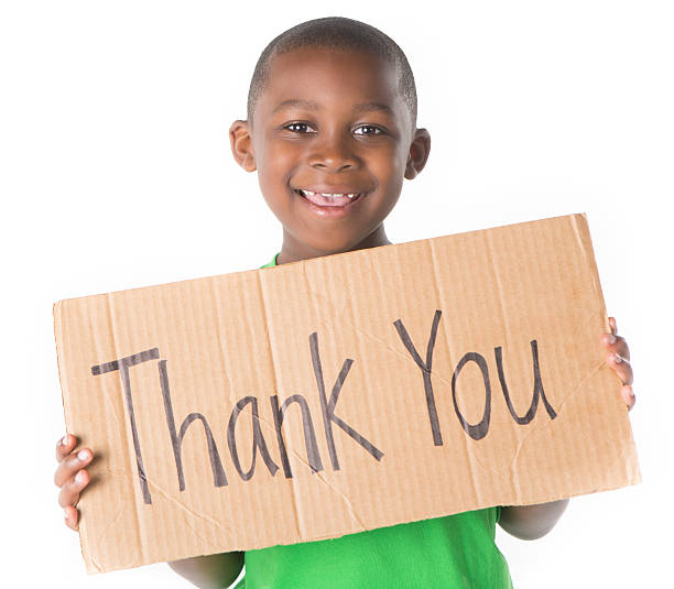 Young boy holding a Thank You sign on white background