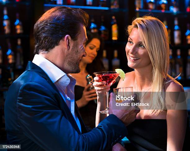 Homem Com Mulher Beber Martinis Em Bar - Fotografias de stock e mais imagens de Adulto - Adulto, Bar - Local de entretenimento, Beber