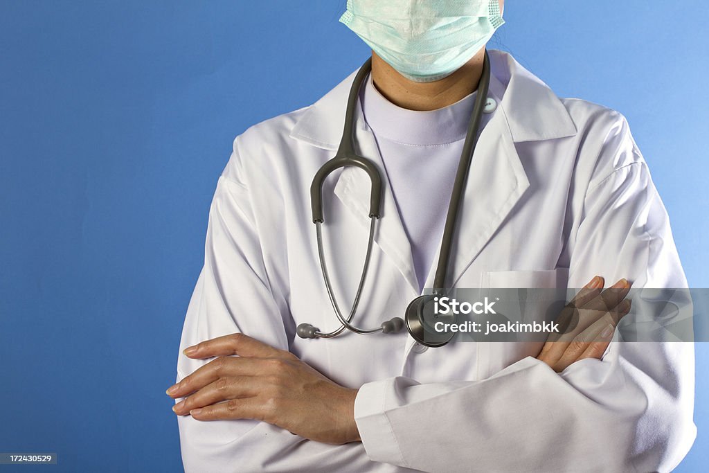 Enfermera con los brazos cruzados sobre fondo azul - Foto de stock de Adulto libre de derechos
