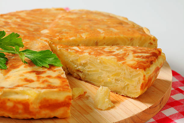 spanish tortilla spanish potato tortilla on a round wooden cutting board and a chequered placemat tortilla de patatas stock pictures, royalty-free photos & images