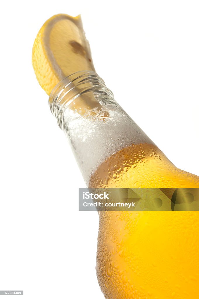 Bottiglia di birra fredda con ghiaccio e limone - Foto stock royalty-free di Limone