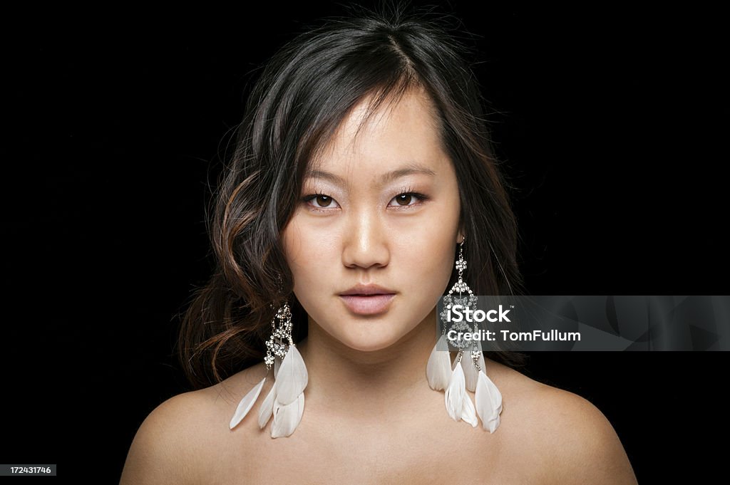 Azji kobieta z pióro kolczyki - Zbiór zdjęć royalty-free (Azjaci)