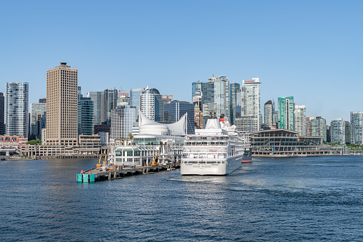 The Silver Whisper cruise ship docking at the Cruise Line Terminal with the downtown  skyscrapers behind, Vancouver, Canada