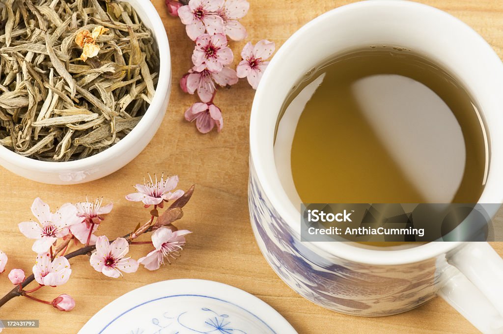 Cup of Jasmine tea with tea leaves and pink blossom Cup of Jasmine tea with a bowl of tea leaves and pink blossom Jasmine Tea Stock Photo