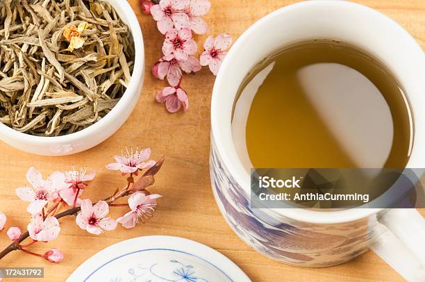 Cup Of Jasmine Tea With Tea Leaves And Pink Blossom Stock Photo - Download Image Now