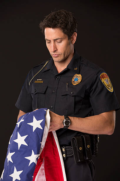 istock Policeman holding an American Flag 172431961