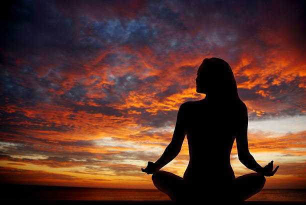 istock Woman meditating at the beach with sunset 172432505