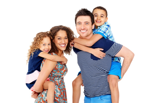 Portrait of playful young parents giving piggyback ride to children on white background