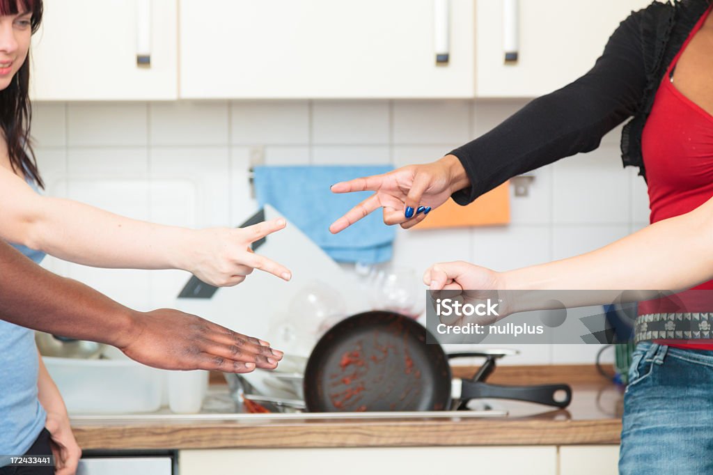 friends arguing over who has to do the dishes Cooking Stock Photo