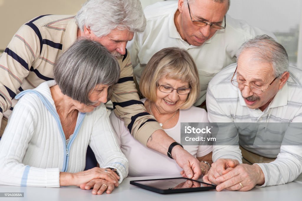 Groupe de personnes âgées examiner Tablette numérique - Photo de 55-59 ans libre de droits