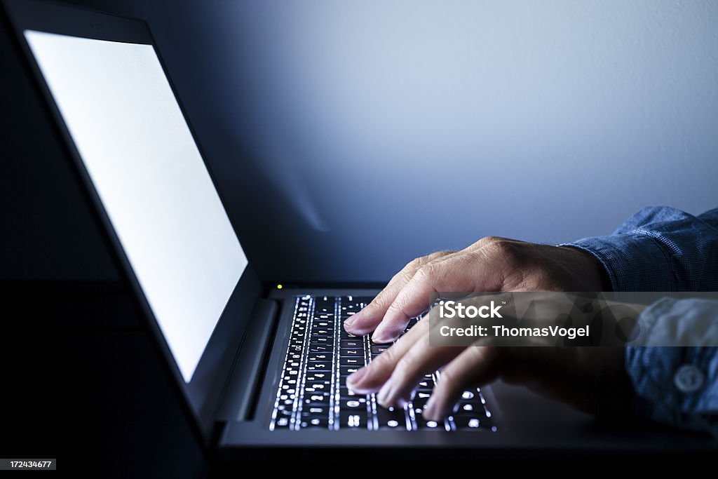 Trabalhando em um laptop iluminado - Foto de stock de Computador royalty-free