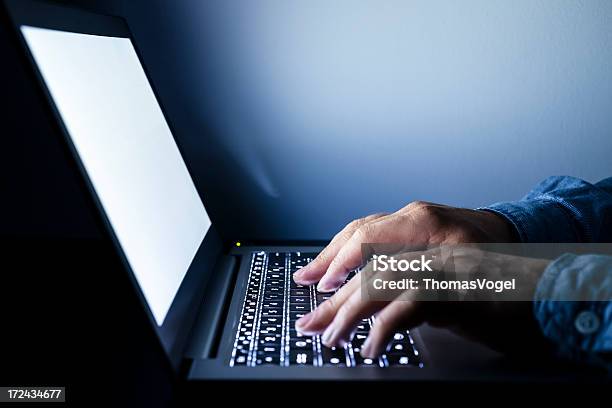 Foto de Trabalhando Em Um Laptop Iluminado e mais fotos de stock de Computador - Computador, Digitar, Escuro