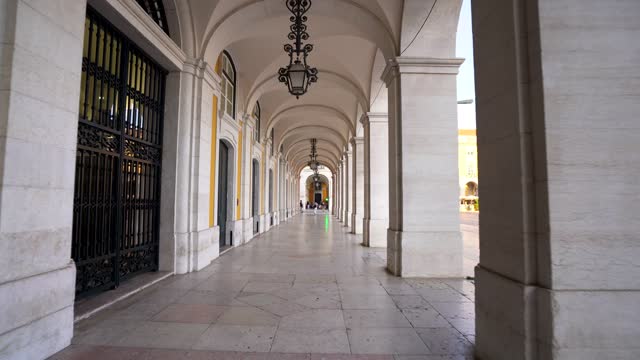 Walking through the arcades of Terreiro do Paco. Located on Praca do Comercio in the city center of Lisbon, Portugal.