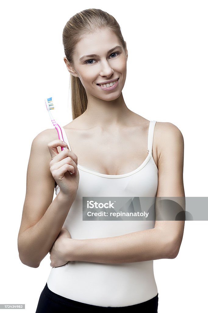 Giovane donna bionda mette con spazzolino da denti isolato su bianco - Foto stock royalty-free di 25-29 anni