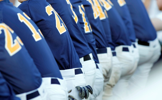 View of the back of a baseball team in blue uniforms.