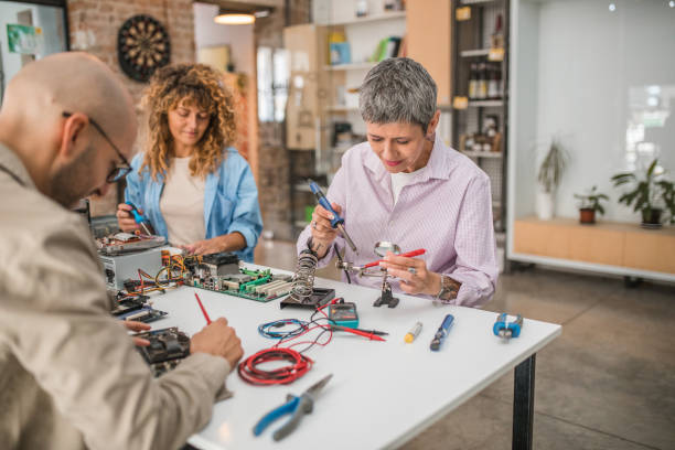 istock A professor shows a small group of students how to solder while learning about computer hardware 1724358059