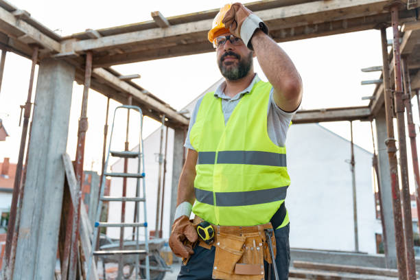 istock Mid-adult Caucasian construction worker, with a tool belt and work tools on a construction site 1724364425