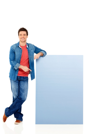 Portrait of happy young guy pointing at empty copyspace over white background