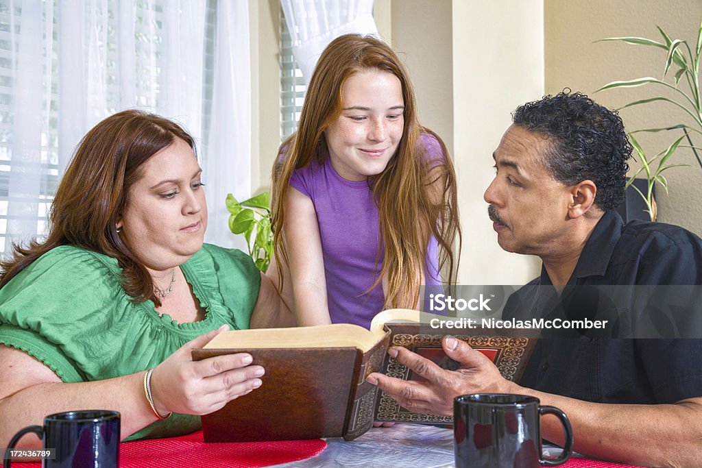 Família discutir Bíblia na mesa da sala de jantar - Foto de stock de Missionário royalty-free