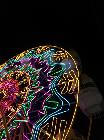 The Ferris wheel can be seen up close with colorful lights