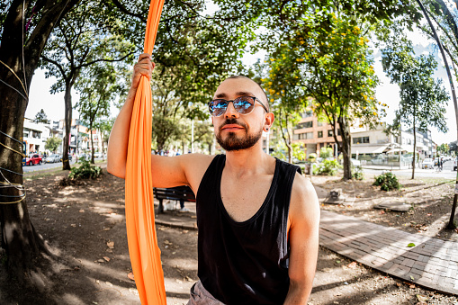 Portrait of a young man practicing silk exercises at the public park