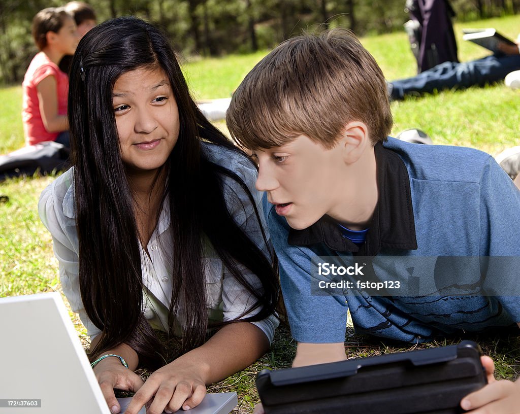 Technologie: Junior high étudiants à l'aide d'un ordinateur portable et une tablette ordinateurs - Photo de 12-13 ans libre de droits