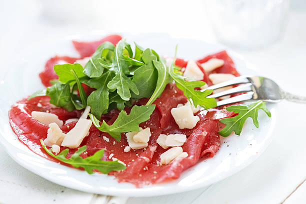 Carpaccio Carpaccio served with arugula and parmesan cheese carpaccio parmesan cheese beef raw stock pictures, royalty-free photos & images