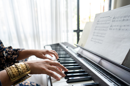 Close-up of a keyboardist performing synthesizer at home