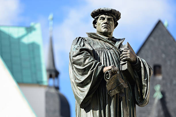 Monument of Martin Luther in Eisleben Monument of Martin Luther in Eisleben, the town of his birth and death, medieval architecture in the background protestantism stock pictures, royalty-free photos & images