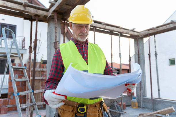 istock Senior Caucasian male architect holding an blueprint, while observing the work on a construction site 1724379453