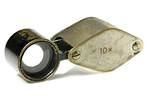 vintage folding magnifier with 10x magnification isolated on white background