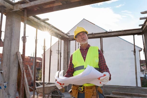 istock Senior Caucasian male architect holding an blueprint, while observing the work on a construction site 1724380591