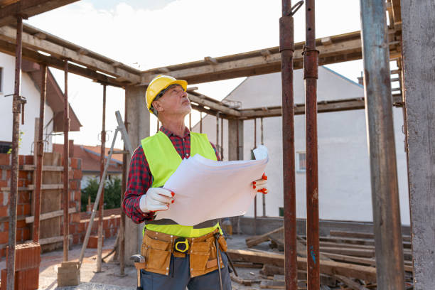 istock Senior Caucasian male architect holding an blueprint, while observing the work on a construction site 1724382285
