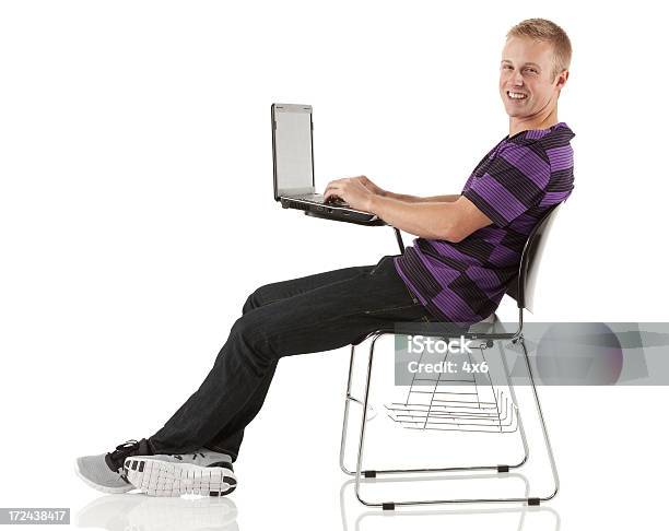 Mann Sitzend Auf Einem Stuhl Mit Einem Laptop Stockfoto und mehr Bilder von Bildung - Bildung, Blick in die Kamera, Computer