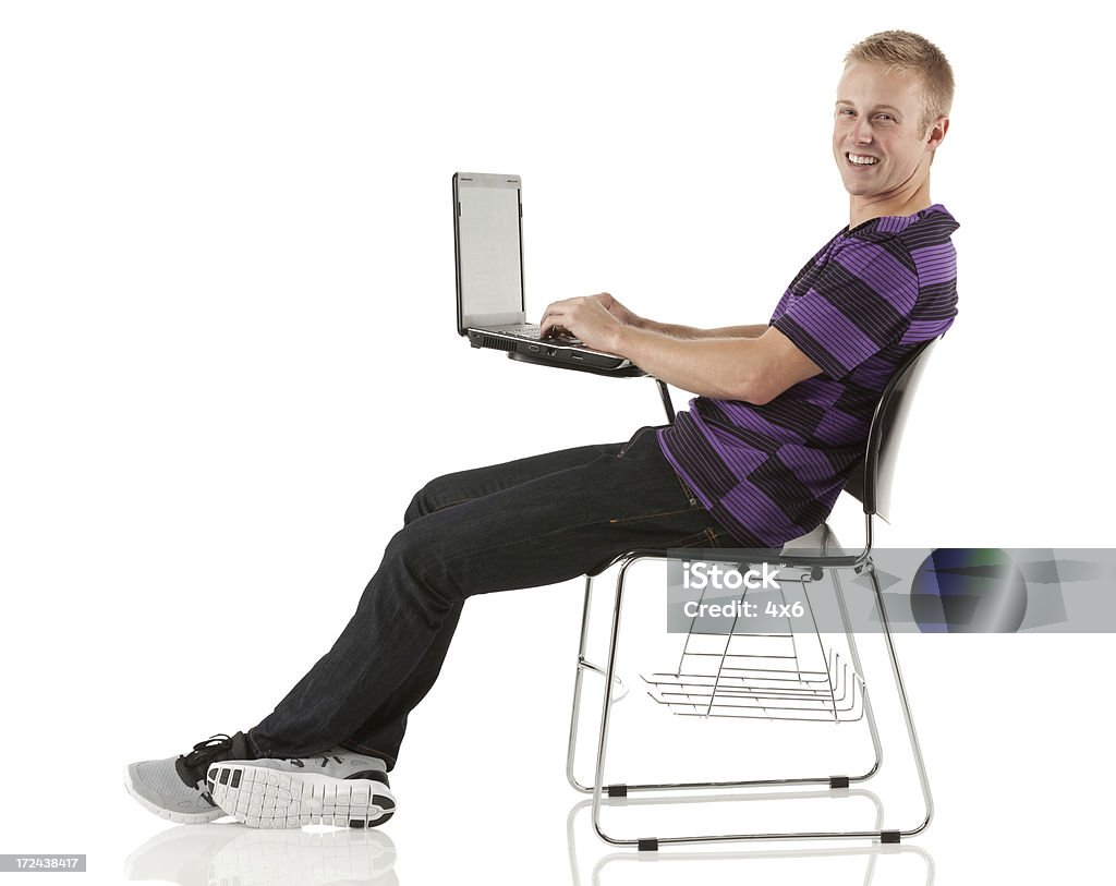 Homem sentado na cadeira de aula, usando um computador portátil - Royalty-free 20-29 Anos Foto de stock