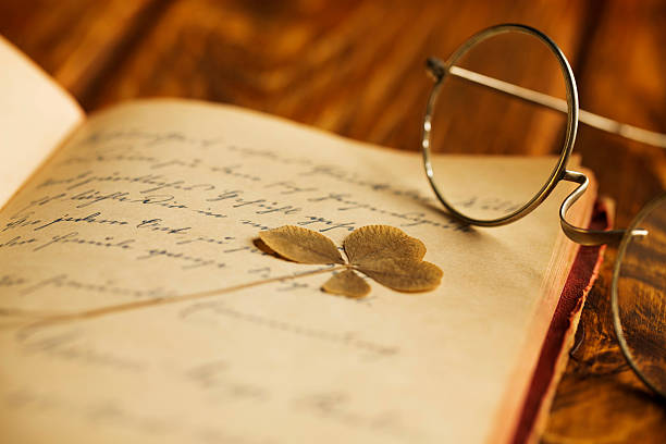 Vintage Poetry and eyeglasses Vintage Poetry. Antique eyeglasses on old German Poesie book, wooden table. Close-up.The grain and texture added. Selective focus. Very shallow depth of field for soft background. poetry literature photos stock pictures, royalty-free photos & images