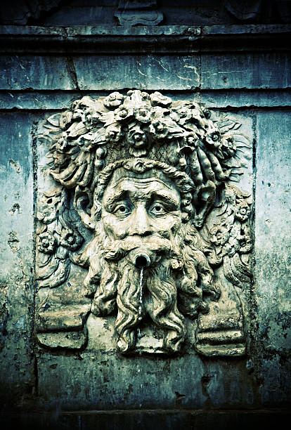 Ornamental water fountain with face and water in focus