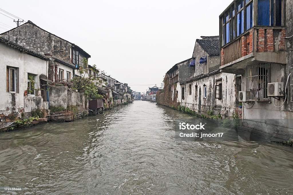 Suzhou Canal Living "This is one of many canals in Suzhou, often referred to as the Venice of th Orient. This home sback up to the canal. You can see many of the home appear very old." Building Exterior Stock Photo