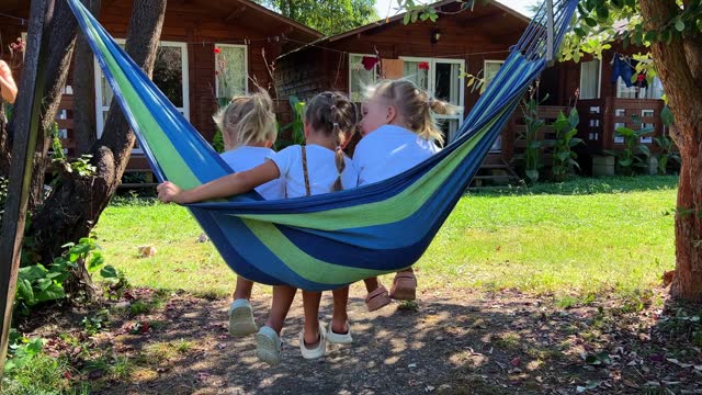 triplets Sisters swinging on a hammock