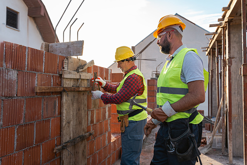 Senior and mid-adult male Caucasian construction workers, working together on a construction site